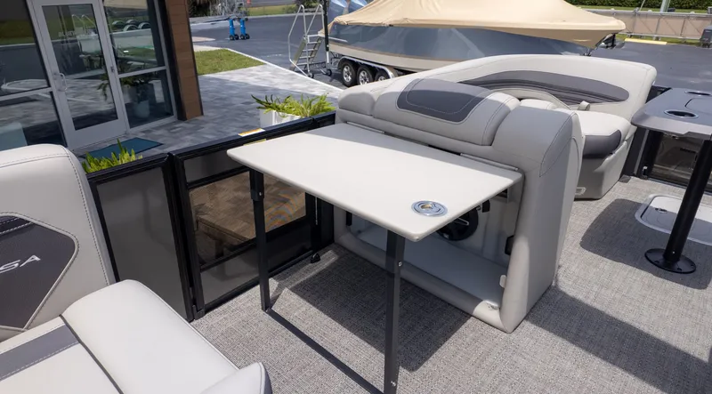 Slide: The Image of The image shows the interior of a 2025 Barletta Corsa 23M boat with a foldable table. - 20