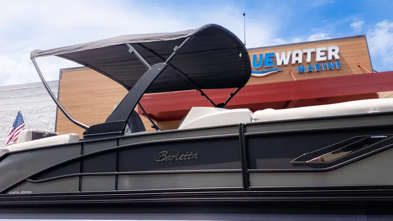Slide: The Image of The image shows a Barletta Corsa 23M boat with a canopy, positioned in front of a building. - 35