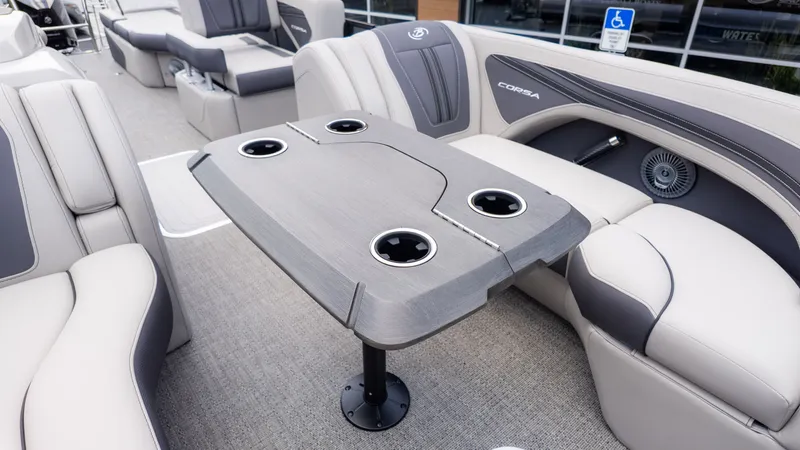 Slide: The Image of Interior of the Barletta Corsa 23M with a gray table and beige seating. - 23
