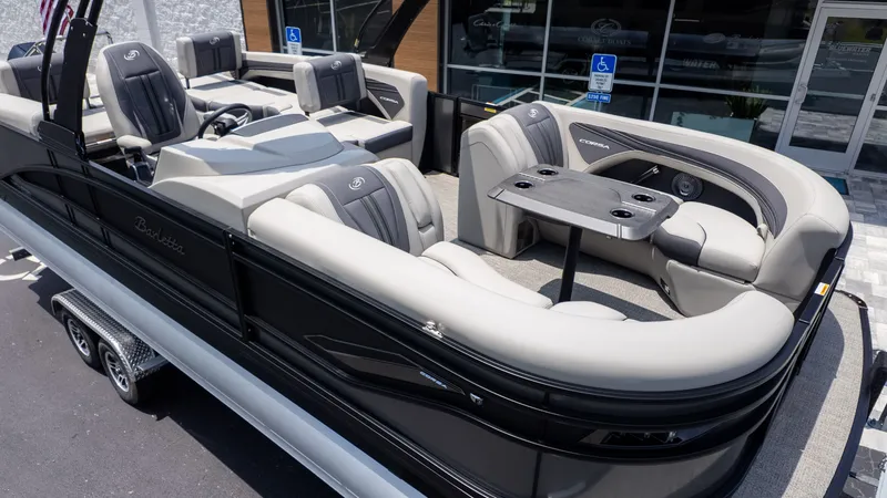 The Image of The image shows a luxurious pontoon boat with sleek seating and a central table. - 1