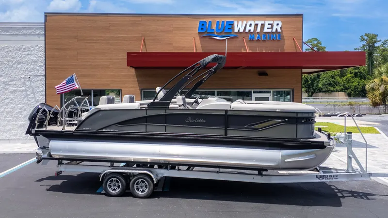 Slide: The Image of 2025 Barletta Corsa 23M on a trailer in front of a building with "Blue Water Marine" sign. - 34