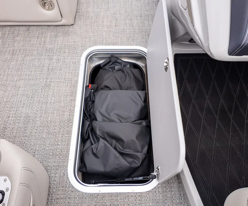 Slide: The Image of A storage compartment on a boat with black bags inside. - 22