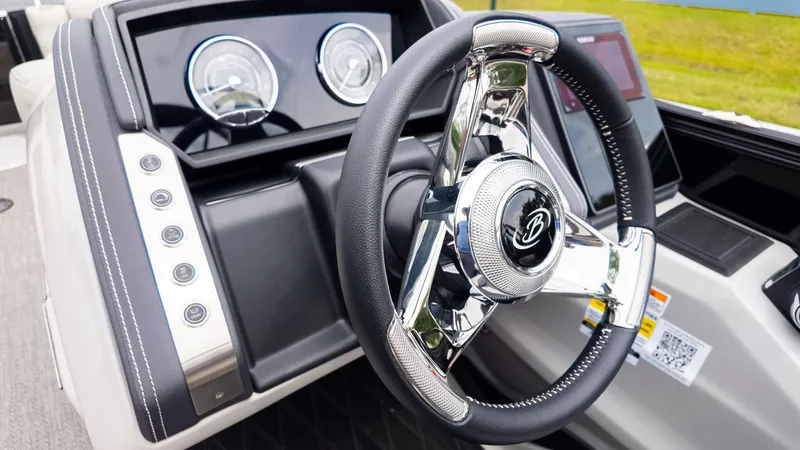 Slide: The Image of The image shows the helm of a Barletta LUSSO 25U boat with a sleek steering wheel and modern gauges. - 25