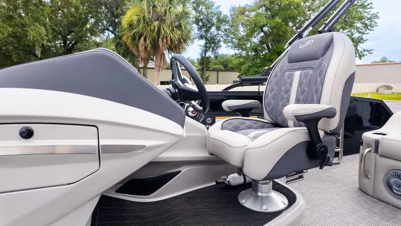 Slide: The Image of The helm of the 2025 Barletta LUSSO 25U with a luxurious captain's chair. - 21