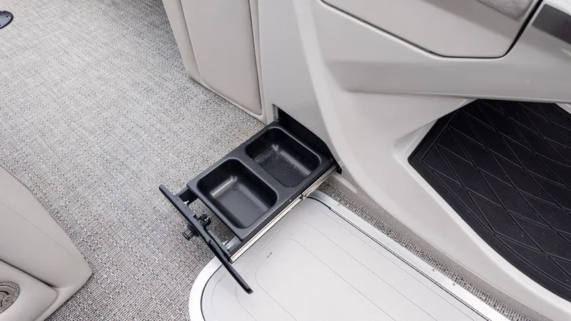 Slide: The Image of A pull-out cup holder in a boat with gray carpet flooring. - 19