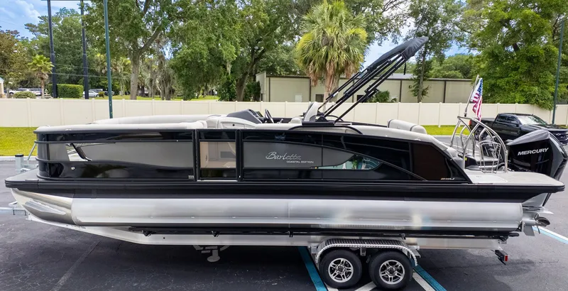 The Image of 2025 Barletta LUSSO 25U on a trailer, featuring sleek lines and a Mercury engine. - 1