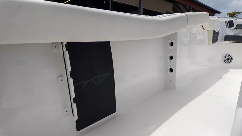Slide: The Image of The image shows the interior of a Tidewater 232 LXF boat with white walls and speakers. - 10