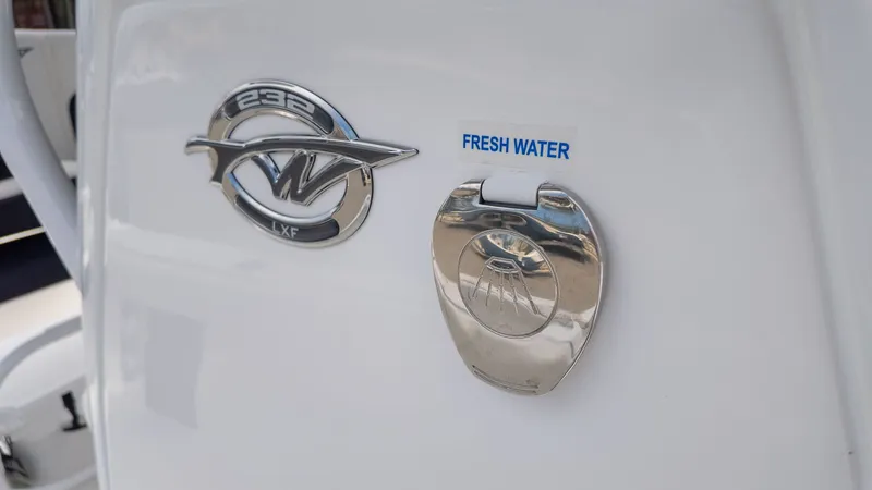 Slide: The Image of Close-up of the logo and fresh water connection on a Tidewater 232 LXF boat. - 19