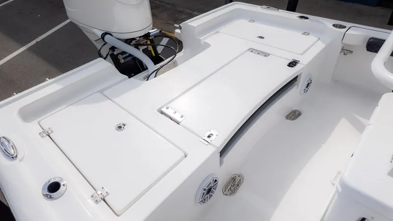 Slide: The Image of The image shows the deck of a Tidewater 2300 Carolina Bay boat with storage and engine. - 5