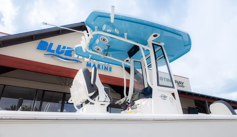 Slide: The Image of A modern boat with a blue roof and white hull in front of a building. - 26