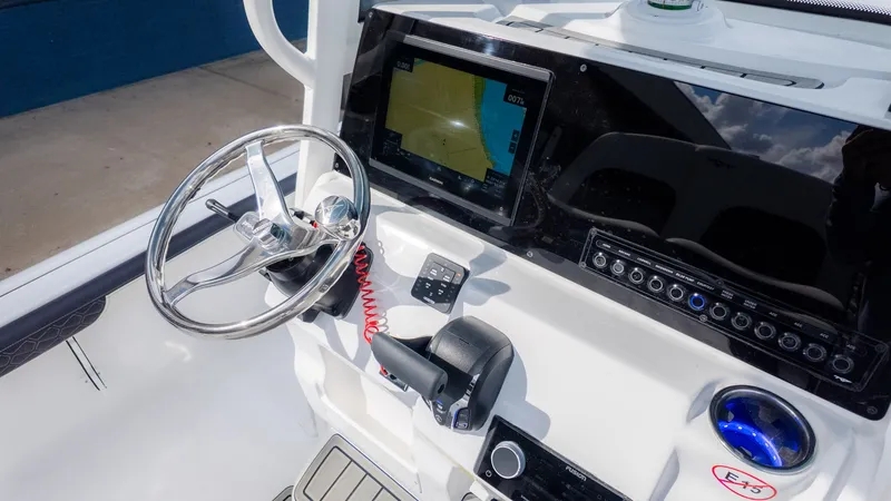 Slide: The Image of The image shows the helm of a Tidewater 2300 Carolina Bay boat with modern electronics. - 14