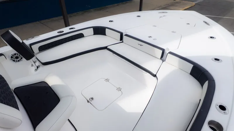 Slide: The Image of The image shows the deck of a Tidewater 2300 Carolina Bay boat with white and black upholstery. - 15