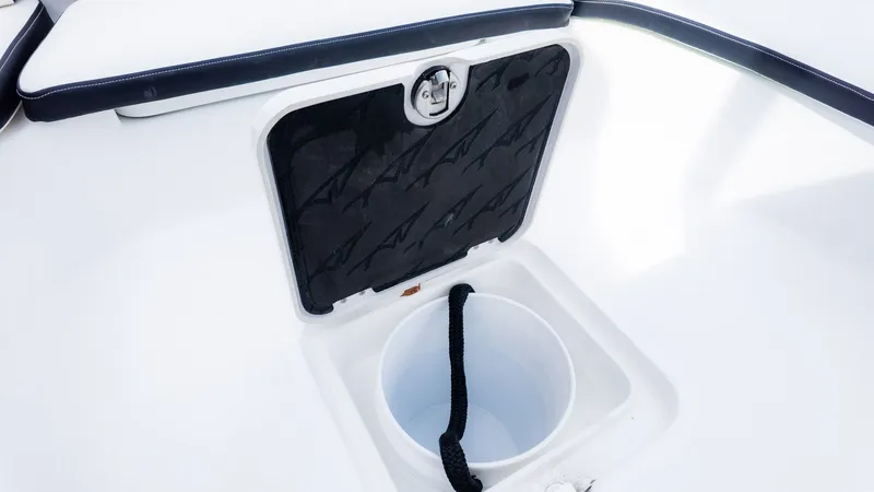 Slide: The Image of A storage compartment with a black lid and rope in a white boat. - 20