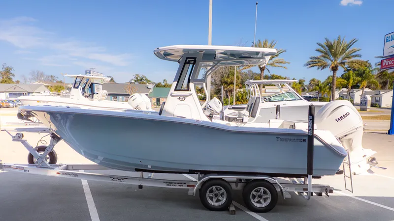 The Image of A 2026 Tidewater 232 LXF boat on a trailer, parked in a lot under sunny weather. - 1
