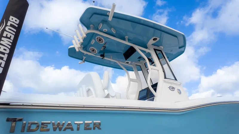 The Image of The image shows a blue and white boat with a modern T-top and multiple fishing rod holders. - 1