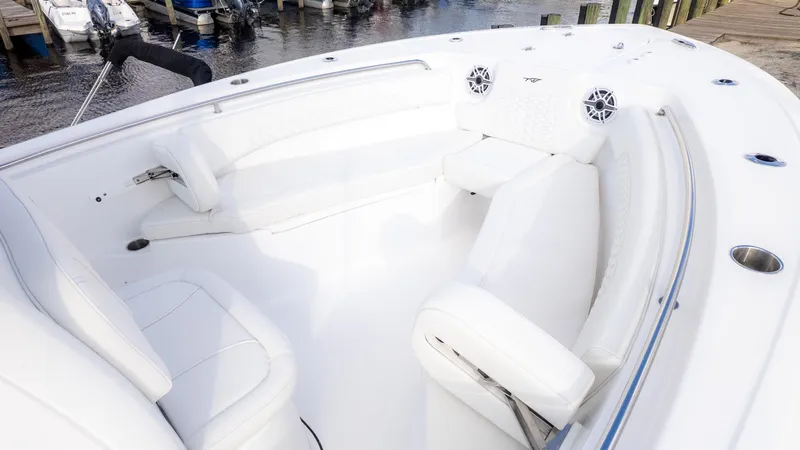 Slide: The Image of The image shows the white cockpit of a Tidewater 232 CC Adventure boat with cushioned seating. - 17