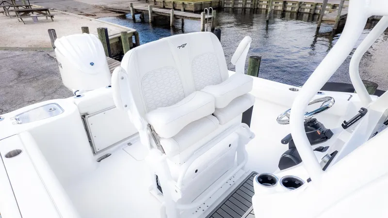 Slide: The Image of The image shows the cockpit of a Tidewater 232 CC Adventure boat with white seating. - 13