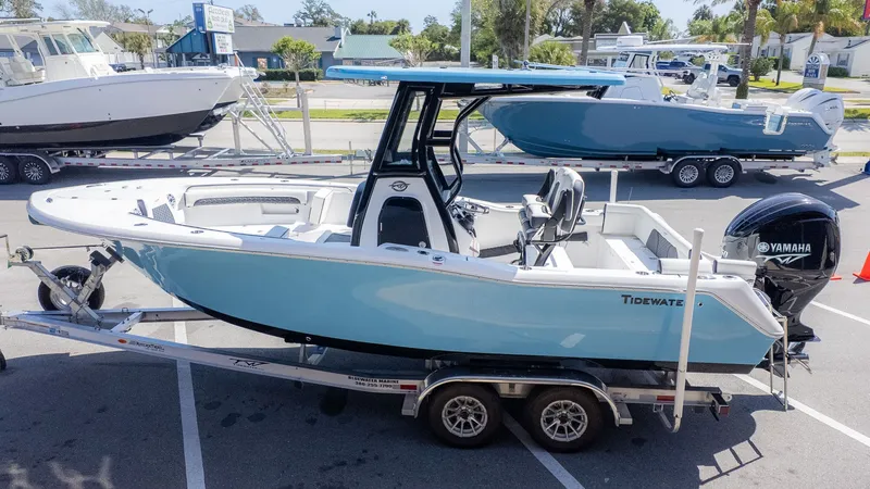 The Image of A light blue Tidewater 232 LXF boat on a trailer, featuring a Yamaha outboard motor. - 1