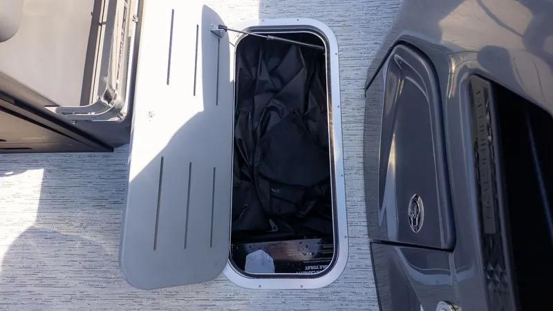 Slide: The Image of An open storage compartment on a boat with gray flooring. - 12