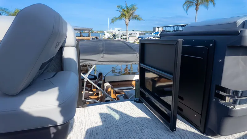 Slide: The Image of The image shows the deck of a Bennington 24 M Stern Lounge boat with gray seats and a black cabinet. - 9