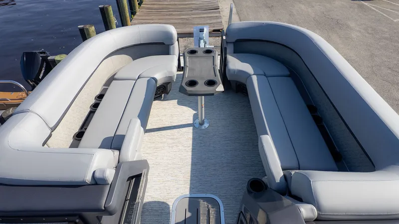 Slide: The Image of The image shows the interior of a Bennington 24 M Stern Lounge boat with gray seating. - 11