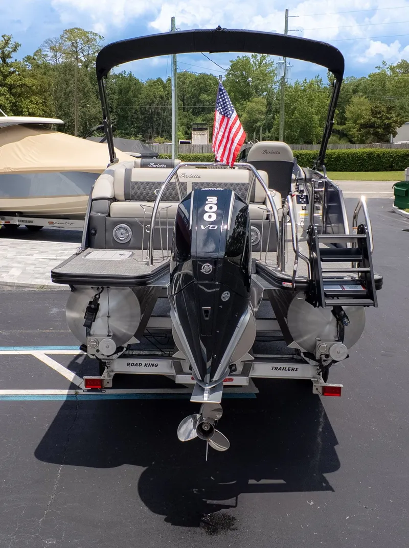Slide: The Image of 2026 Barletta Lusso 23U with outboard motor and American flag, on a trailer. - 6