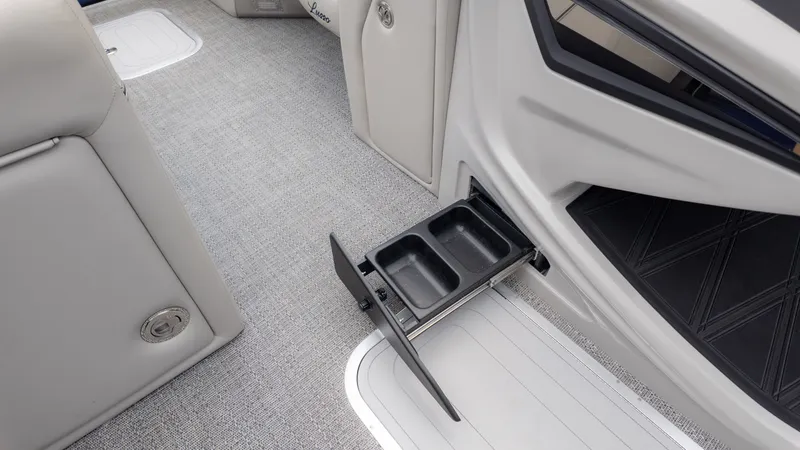 Slide: The Image of A pull-out cup holder in a boat with gray carpet flooring. - 25