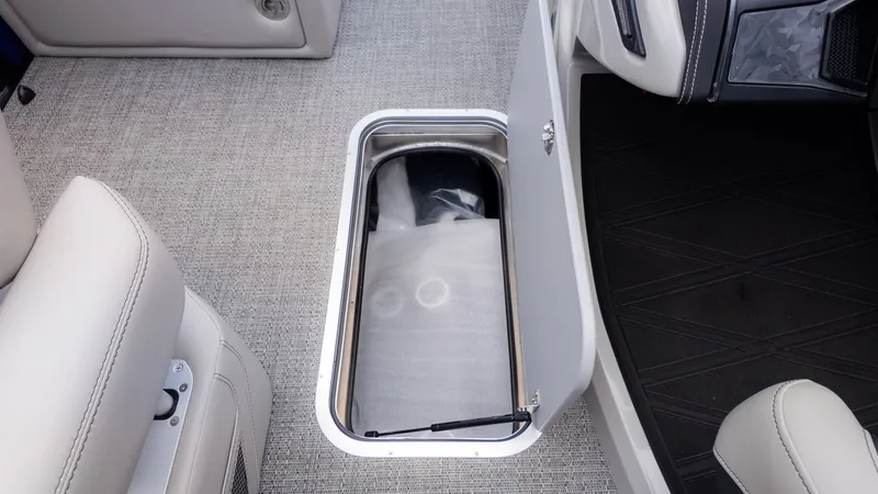 Slide: The Image of A storage compartment in the floor of a Barletta Lusso 23U boat with gray carpeting. - 18