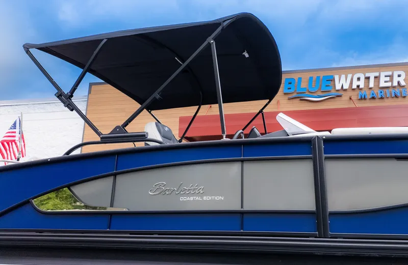 Slide: The Image of 2026 Barletta Lusso 23U with sunshade, in front of a building with an American flag. - 30