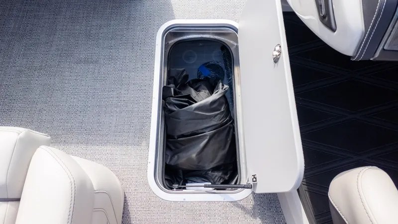 Slide: The Image of An open floor storage compartment on a boat with a black cover inside. - 16