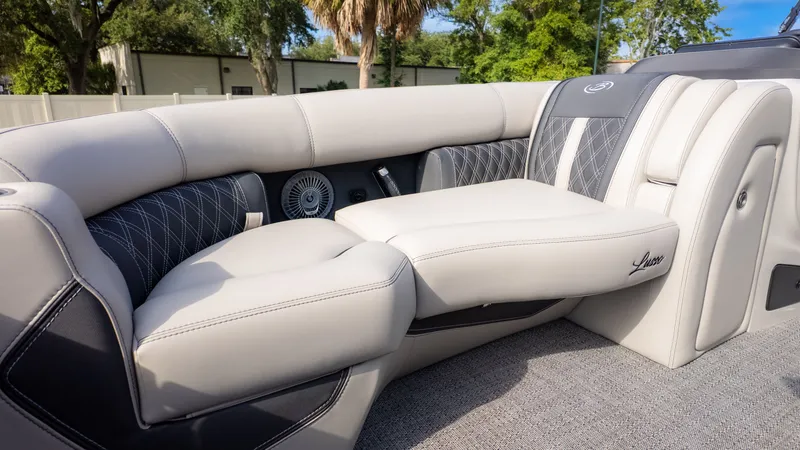 Slide: The Image of Luxurious seating area on a Barletta Lusso L23M pontoon boat, surrounded by trees. - 19