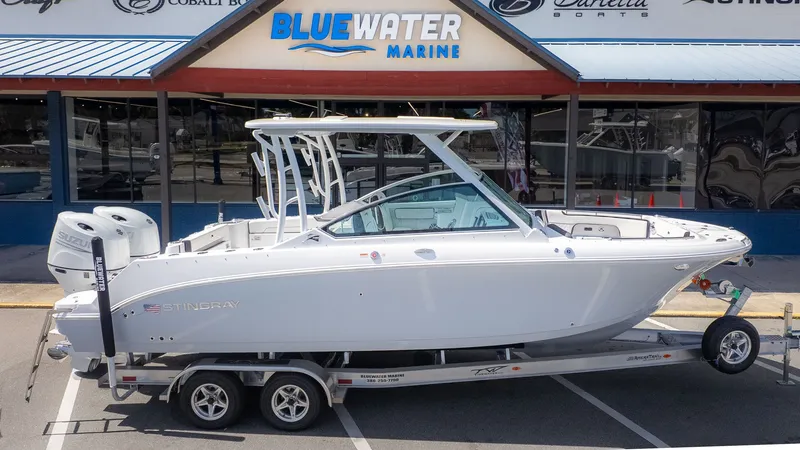 Slide: The Image of A white 2026 Stingray 259 DC boat on a trailer in front of a store. - 34