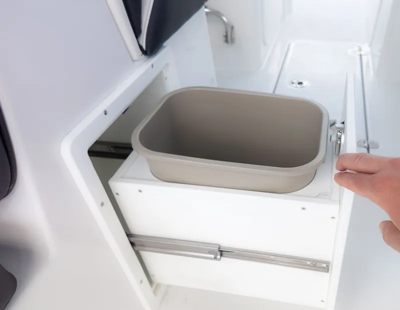 Slide: The Image of A pull-out storage compartment with a gray bin on a boat. - 19