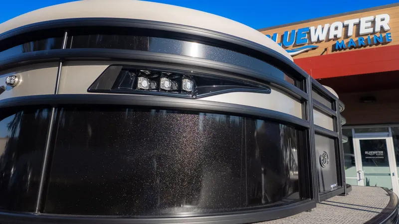 Slide: The Image of Close-up of the Barletta Corsa X23U boat in front of a building with "Bluewater Marine" sign. - 3