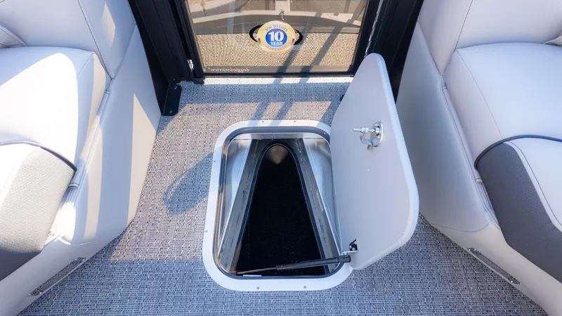 Slide: The Image of An open storage compartment in the floor of a boat with gray carpeting. - 20