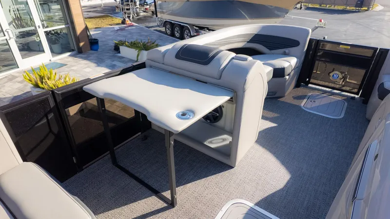 Slide: The Image of The image shows the interior of a Barletta Corsa X23U boat with a table and seating. - 14