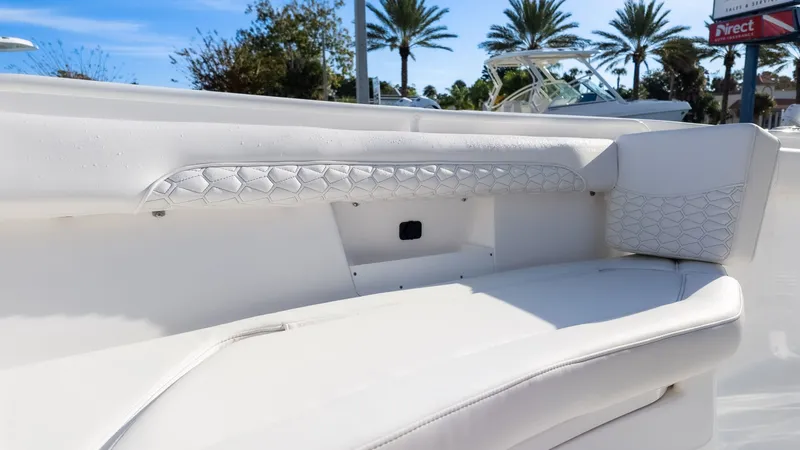 Slide: The Image of The image shows a white seating area on a boat with padded details and palm trees in the background. - 22