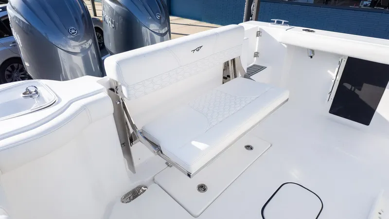 Slide: The Image of Tidewater 256 CC Adventure 2026: White bench seat in the rear area with two outboard motors in the background. - 11