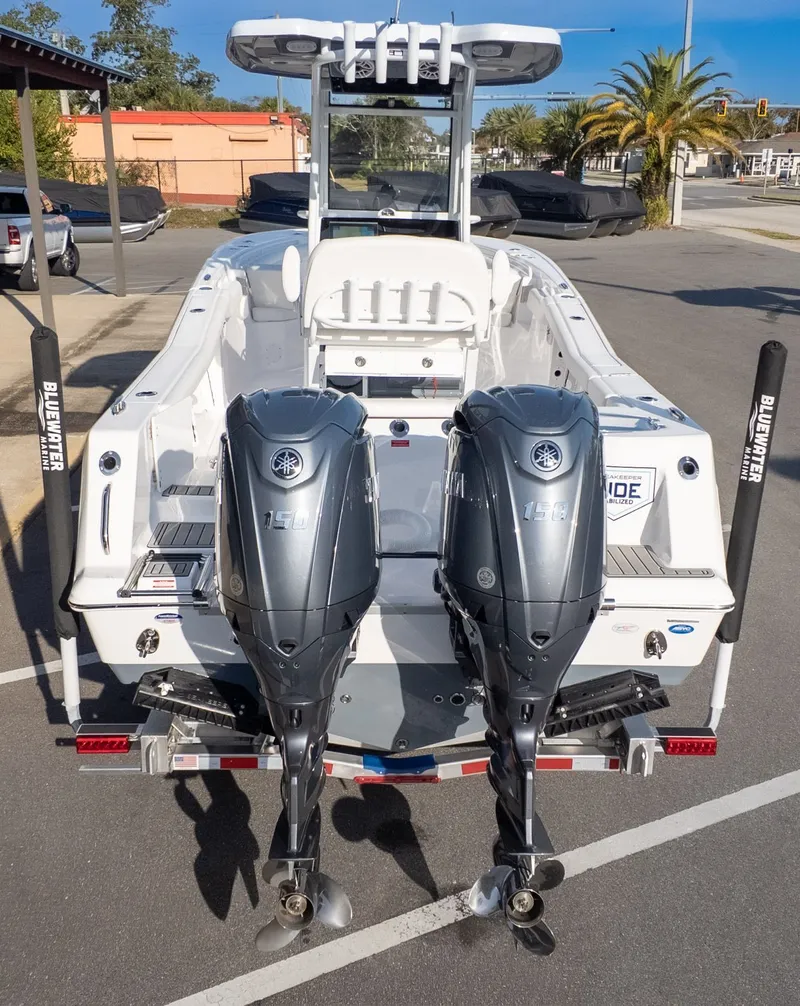 Slide: The Image of The image shows a Tidewater 256 CC Adventure boat with two outboard engines in a parking lot. - 4