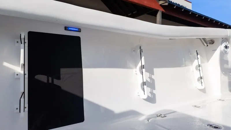 Slide: The Image of The image shows the deck of a Tidewater 256 CC Adventure boat with fishing rod holders. - 10