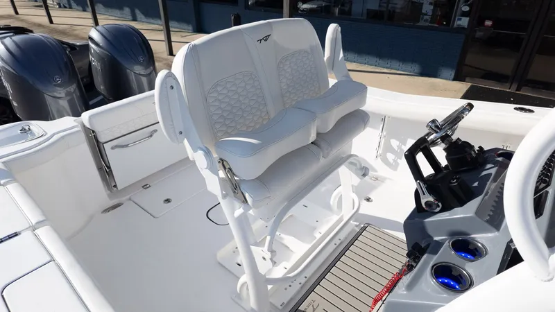 Slide: The Image of The image shows the cockpit of a Tidewater 256 CC Adventure boat with white seats and helm. - 12