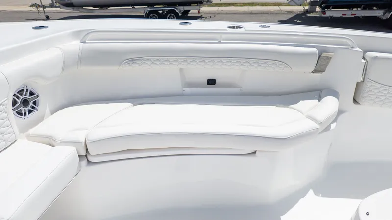 Slide: The Image of The image shows a boat's white seating area with cushioned seats and speakers. - 13