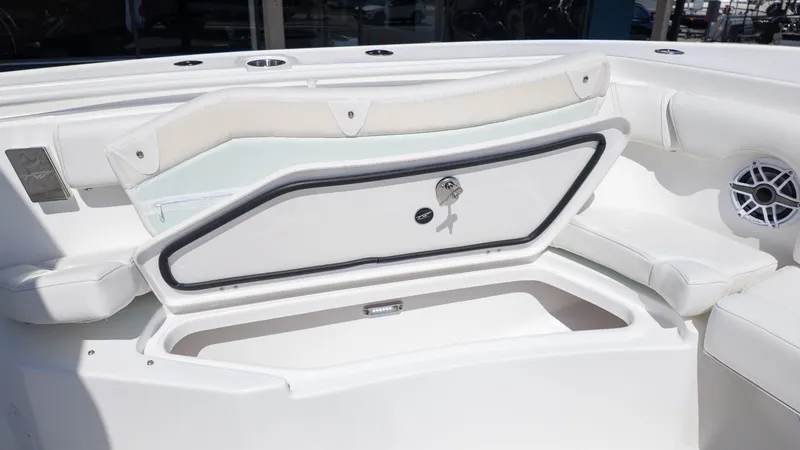 Slide: The Image of An open storage compartment on a white boat with cushioned seating and a speaker. - 12