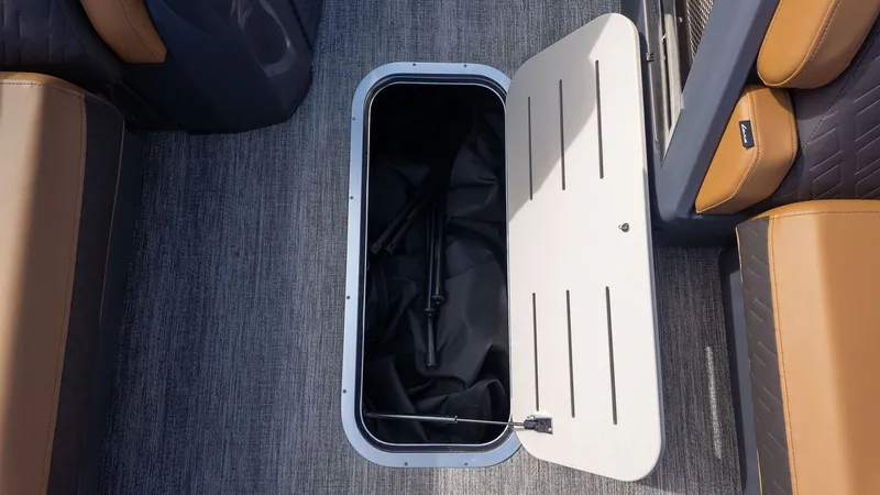 Slide: The Image of An open storage compartment in the floor of a boat with brown seats. - 21