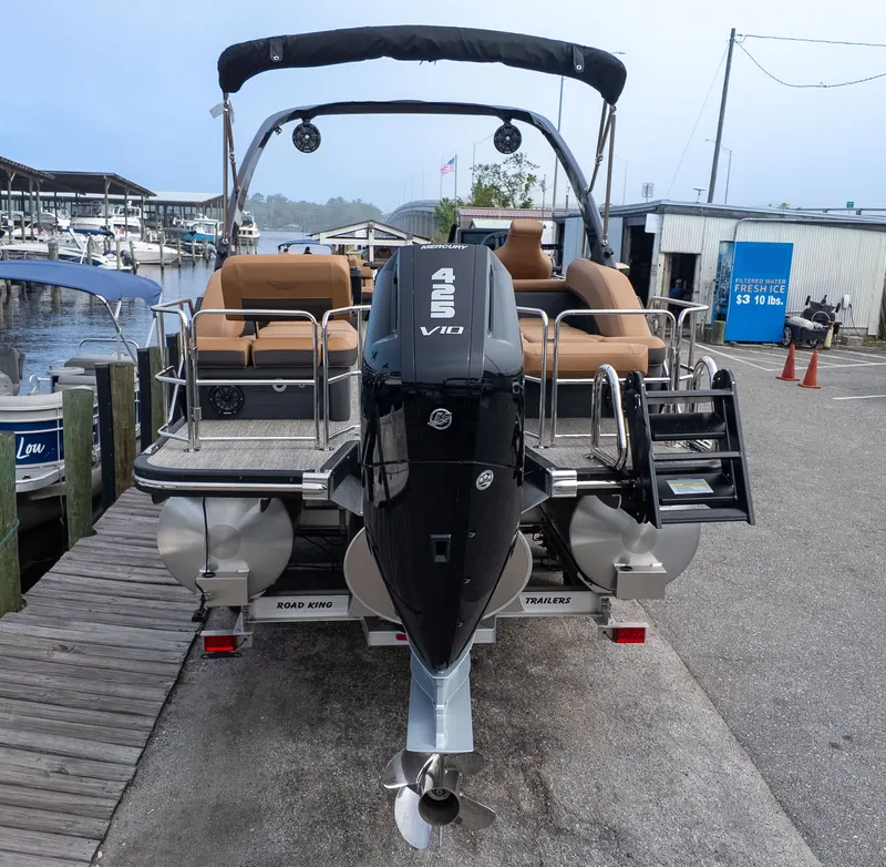 Slide: The Image of The image shows a Bennington 26 M STERN LOUNGE boat at the dock with a powerful outboard motor. - 5