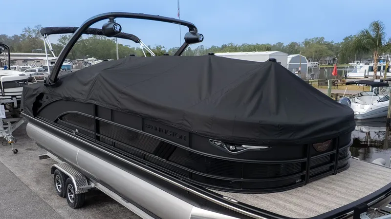 Slide: The Image of Bennington 26 M STERN LOUNGE 2026 covered on a trailer. - 26
