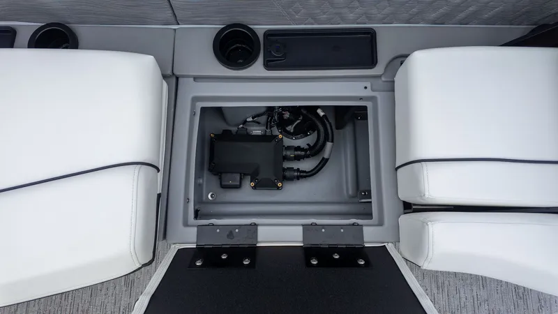 Slide: The Image of An open storage compartment between two white seats reveals electrical connections. - 6