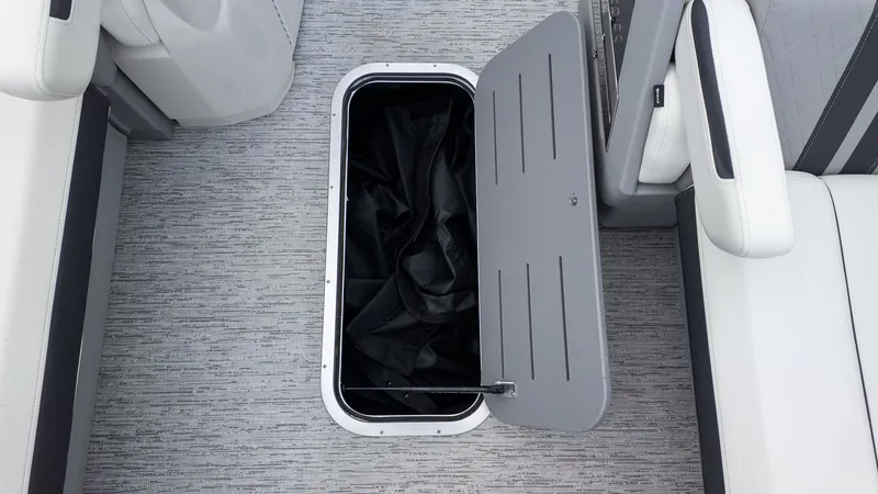 Slide: The Image of An open storage compartment in the floor of a boat with gray carpeting. - 17