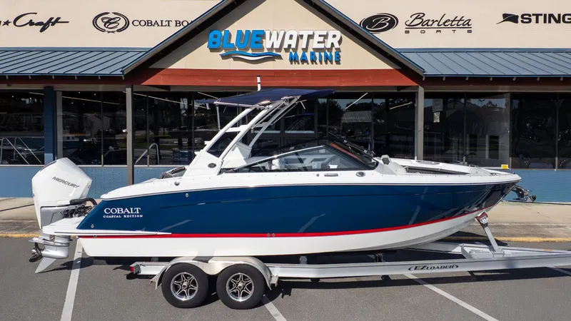 Slide: The Image of A 2026 Cobalt R6 boat on a trailer in front of a store named Blue Water Marine. - 29