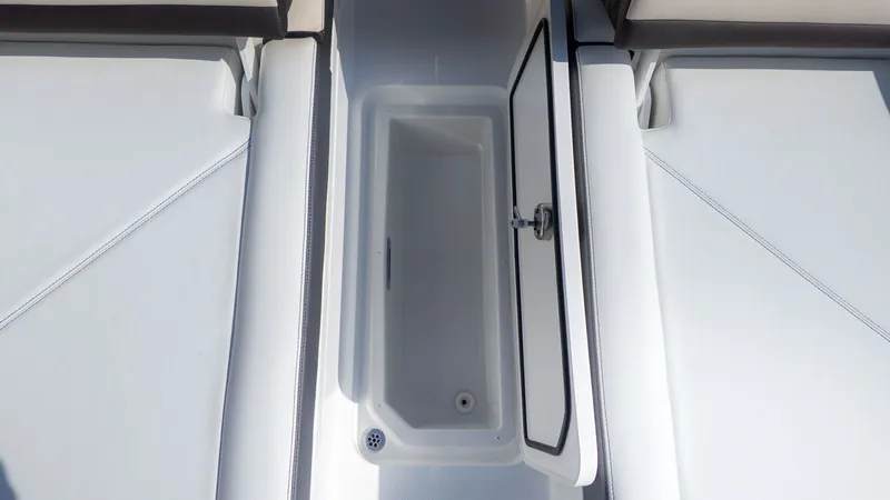 Slide: The Image of An open storage compartment on a Cobalt R6 boat, surrounded by white upholstery. - 8